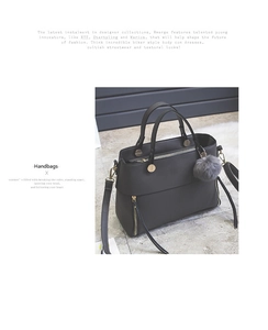 Close-up of vintage grey tote bag featuring gold zippers and plush pom-pom charm