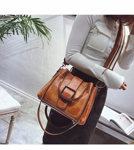 Brown vintage faux leather crossbody bag with striped wide shoulder strap and metal buckle