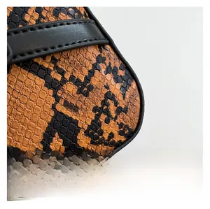 Macro detail of snake skin pattern texture and premium stitching on the crossbody bag