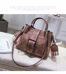 Detailed view of brown matte leather bag with contrast stitching and metal buckle