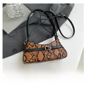 Close-up of orange-brown snake skin pattern on baguette bag with belt buckle detail