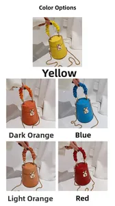 Detail view of crocodile pattern bucket bags in yellow, blue, and red with gold chain strap