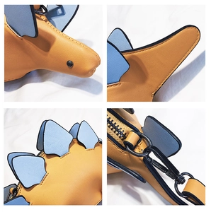 Detail view of colorful dinosaur bag showing smooth metal zipper and blue fin texture