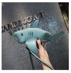 Detail view of mini shark-shaped crossbody bag in light blue faux leather with zipper