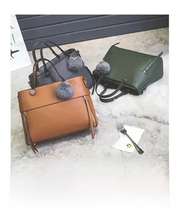 Detailed trio of leather tote bags with vertical zippers and soft fur ball charms