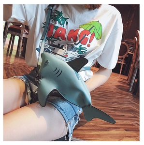 Detail of shark-shaped crossbody bag with fins and adjustable strap on model