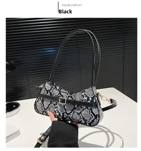 Detail of black and white snakeskin texture on a chic crossbody bag with gold hardware