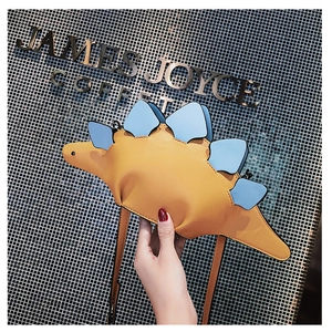 Detail of creative stegosaurus dinosaur bag with yellow body and blue bone plates