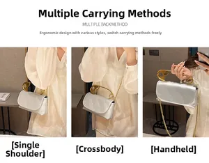 Silver shoulder bag with large gold safety pin handle and detachable chain strap detail