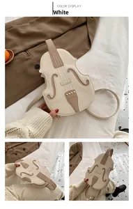 Detail of violin shaped crossbody bag in white faux leather with gold rivet accents