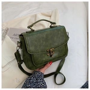 Detail view of the vintage green PU leather square bag with a bronze twist-lock clasp