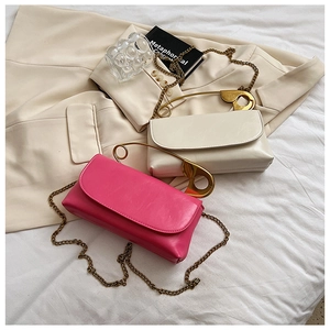 Detail shot of flap chain bags in cream white and rose pink with gold pin handle