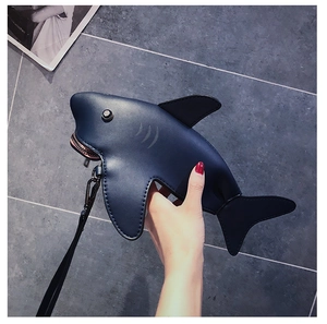 Detail of shark-shaped mini pouch in dark blue PU leather with a wrist strap and zipper
