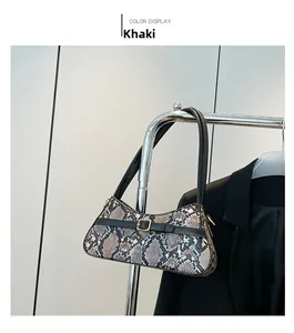 Detail of khaki snake pattern baguette bag with golden metal buckle and black strap