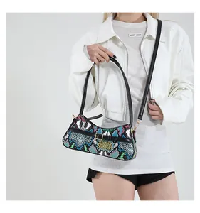 Detailed view of colorful snakeskin baguette bag with black strap and gold buckle