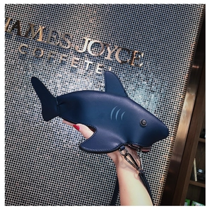 Detailed view of the dark blue shark shaped leather bag with silver metal hooks
