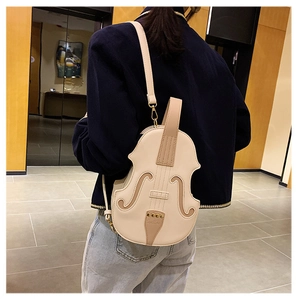 Close-up of cream violin-shaped crossbody bag featuring detailed musical instrument embroidery