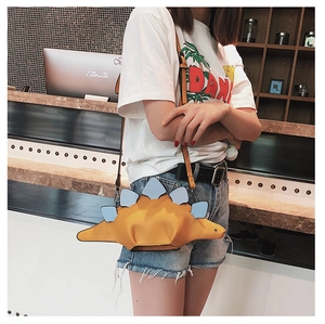 Detailed view of a yellow dinosaur-shaped crossbody bag with blue spine and long strap