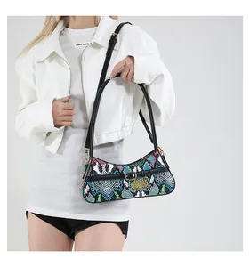 Close-up of colorful snake print handbag with metallic buckle on white fashion outfit