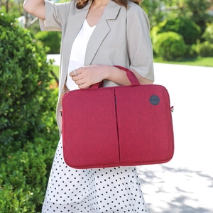Red 15-inch laptop case in frosted fabric held by a model in a sunny park setting