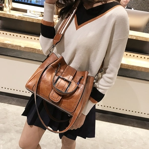 Retro brown faux leather lady bag with vintage studs and buckle strap on model