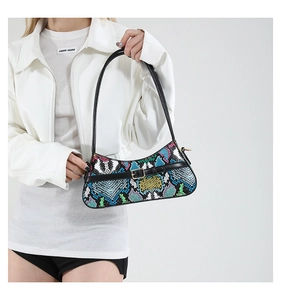 Detail of colorful snakeskin pattern baguette bag with black leather strap and gold buckle