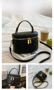 Close-up of black quilted cylinder bucket bag with gold zippers and leather strap