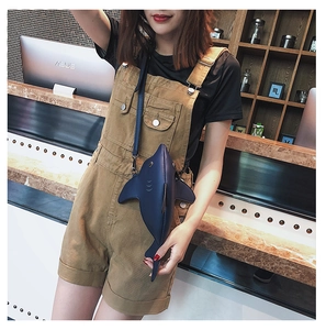 Close-up of a creative navy blue shark-shaped crossbody bag worn by a female model