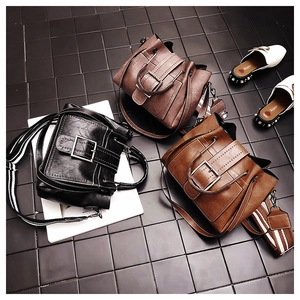 Close-up of vintage faux leather tote bags with square buckles and striped straps