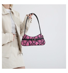 Detail shot of pink snake-pattern leather handbag with black strap and buckle decoration