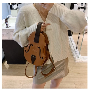 Detailed close-up of a vintage brown violin-shaped backpack with F-hole accents