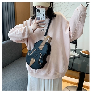 Detail of creative violin-shaped crossbody bag featuring contrasting colors and logo
