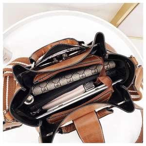 Internal view of the brown leather bag showing spacious compartments for tablets and wallets