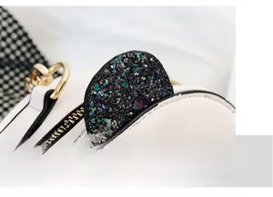 Macro detail of white leather panda bag with colorful sequins and golden hardware