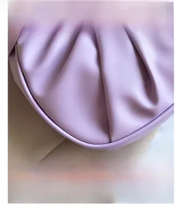 Detail view of purple leather bag featuring soft pleated texture and fine craftsmanship
