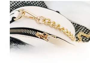 Macro detail of high-quality gold zipper and chain strap on white sequin panda bag