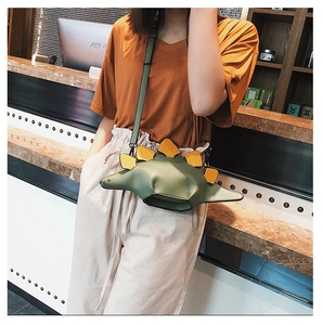 Detail of creative stegosaurus crossbody bag with green leather and yellow dorsal plates