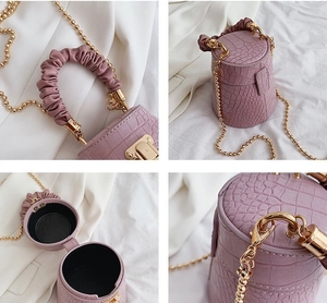 Detailed views of a lilac crocodile pattern bucket bag with gold chain and pleated handle