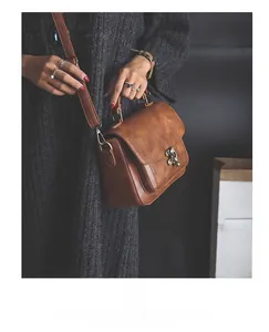 Close-up of brown vintage PU leather messenger bag with retro metal clasp and handle