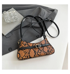 Top-down view of a vintage faux snake skin baguette bag with gold buckle detail on a suit