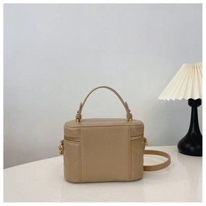 Detail of khaki quilted box bucket bag with gold hardware and cylindrical handle