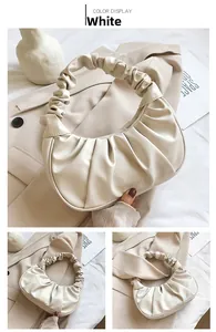 Detail of white pleated cloud bag with soft ruched handles and half-moon silhouette