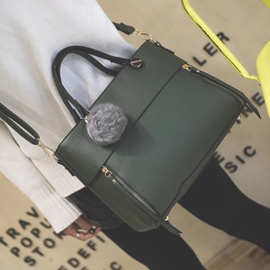 Fashionable dark green leather tote bag with grey fur ball charm and gold zippers