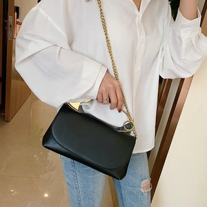 Chic black leather shoulder bag with golden chain strap and unique circular handle
