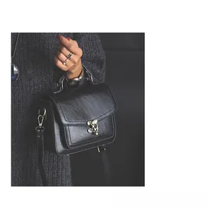 Detail of vintage black PU leather handbag with antique bronze twist lock closure