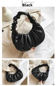 Detail view of black ruched dumpling bag featuring elegant pleated handle and soft PU texture