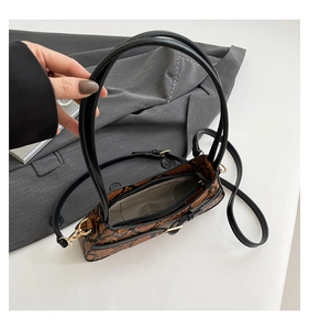Detail of snake print crossbody bag with gold zipper and light fabric lining inside