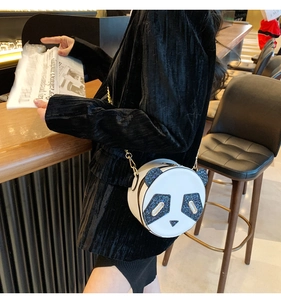 Detail of cute panda-shaped crossbody bag with blue sequin eyes and gold metal chain