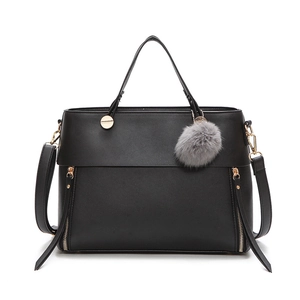 Classic black leather tote bag with gold hardware and a gray fur pompom keychain charm