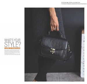 Close-up of a black PU leather handbag featuring a vintage bronze buckle and textured finish